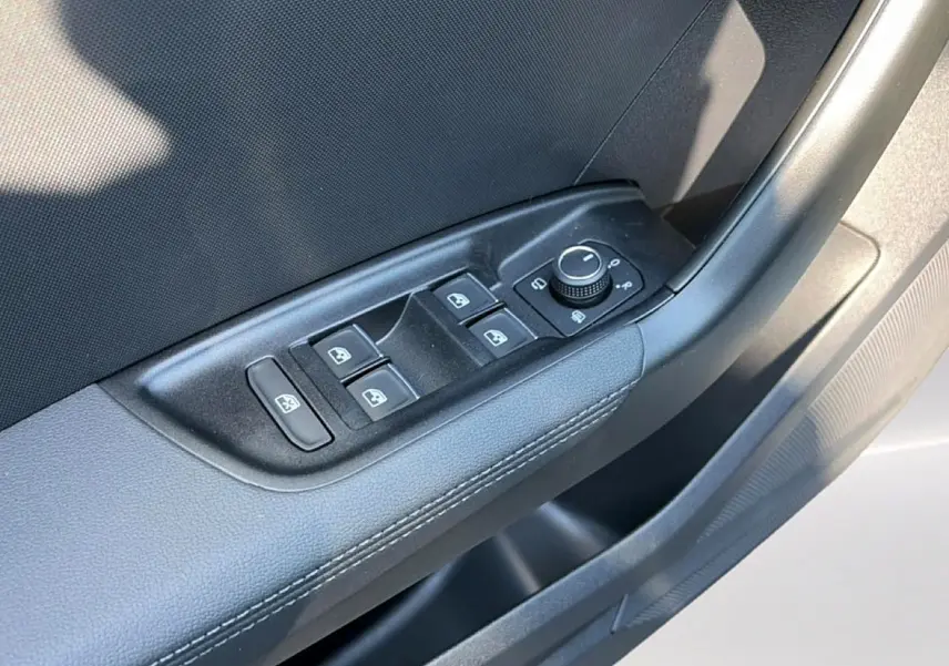 Gros plan sur la commande des vitres électriques et rétroviseurs sur la porte côté conducteur d'une Audi A1 Sportback noire.