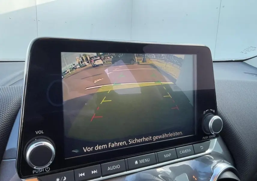 Écran central du Nissan Juke 2024 affichant la caméra de recul avec lignes de guidage colorées.