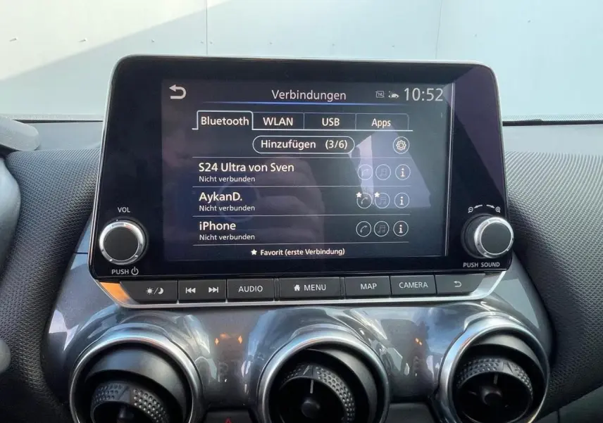 Écran tactile central du Nissan Juke II 2024 avec commandes audio et climatisation, finition gris céramic.