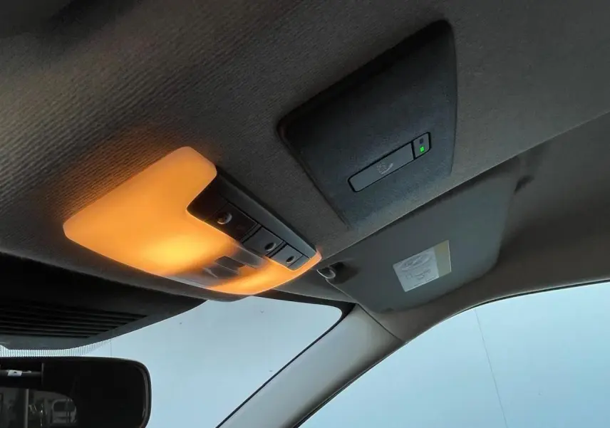 Plafonnier intérieur allumé avec capteur et pare-soleil côté conducteur d'un Nissan Juke II gris ceramic 2024