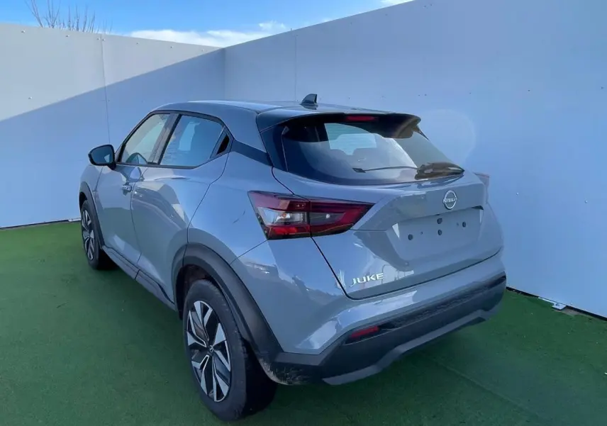 Nissan Juke II gris ceramic vu en 3/4 arrière droit, avec jantes alliage noires et toit noir contrasté.
