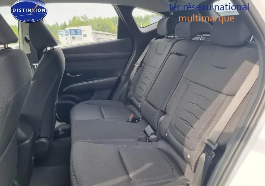 Vue latérale des sièges arrière noirs du Hyundai Tucson 2025 blanc atlas, avec ceintures et appuie-têtes visibles.