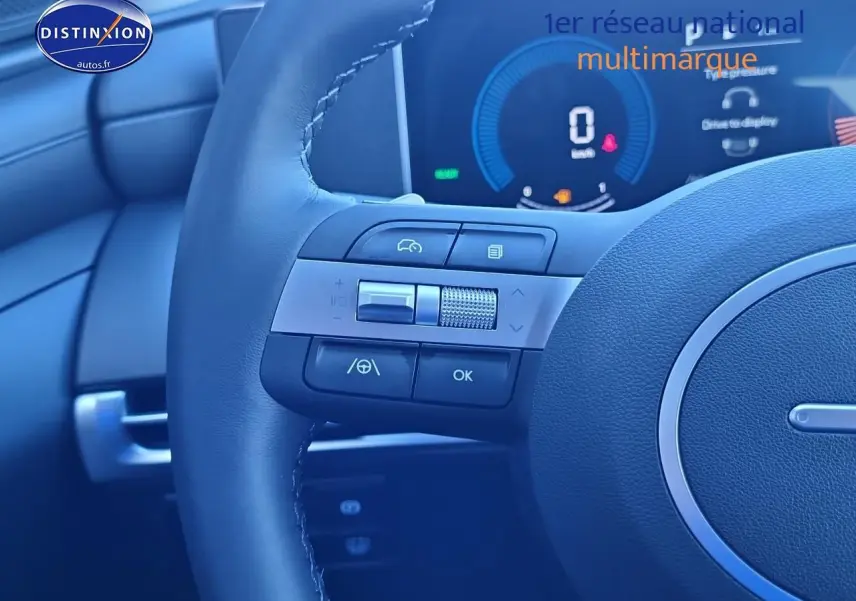 Gros plan sur le volant cuir du Hyundai Tucson 2025 avec commandes multifonctions et tableau de bord numérique.