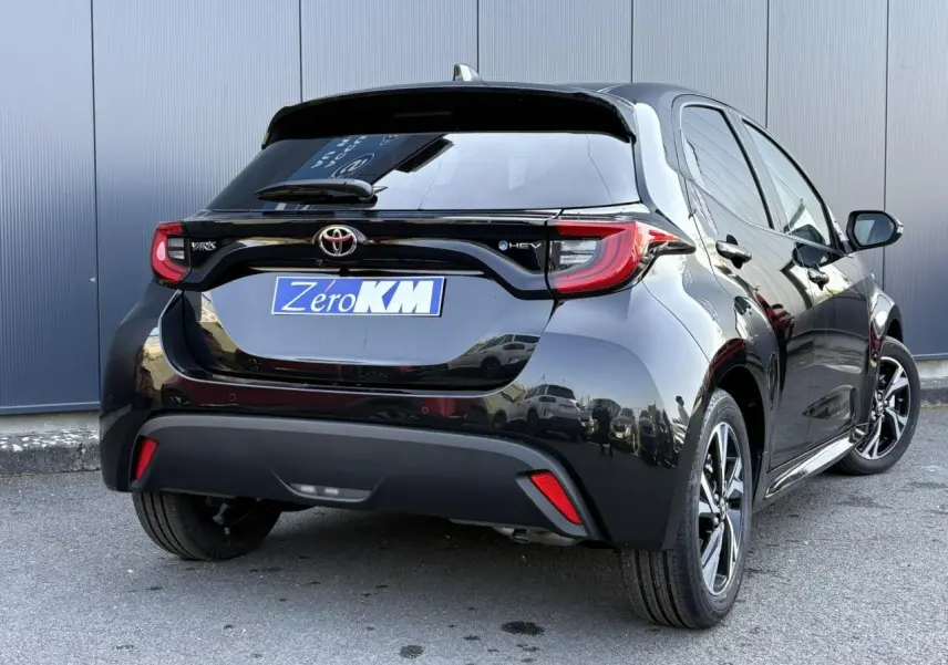 Vue 3/4 arrière droite d'une Toyota Yaris Hybride 2025 noir intense avec feux arrière LED et jantes alliage 16 pouces.