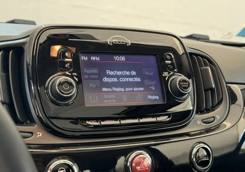 Vue rapprochée du tableau de bord noir brillant de la Fiat 500 2019 avec écran tactile affichant la recherche Bluetooth.