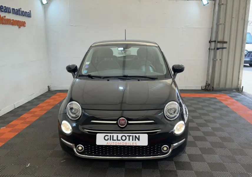 Vue frontale d'une Fiat 500 noire 2019 avec phares allumés et logo Fiat visible sur la calandre.