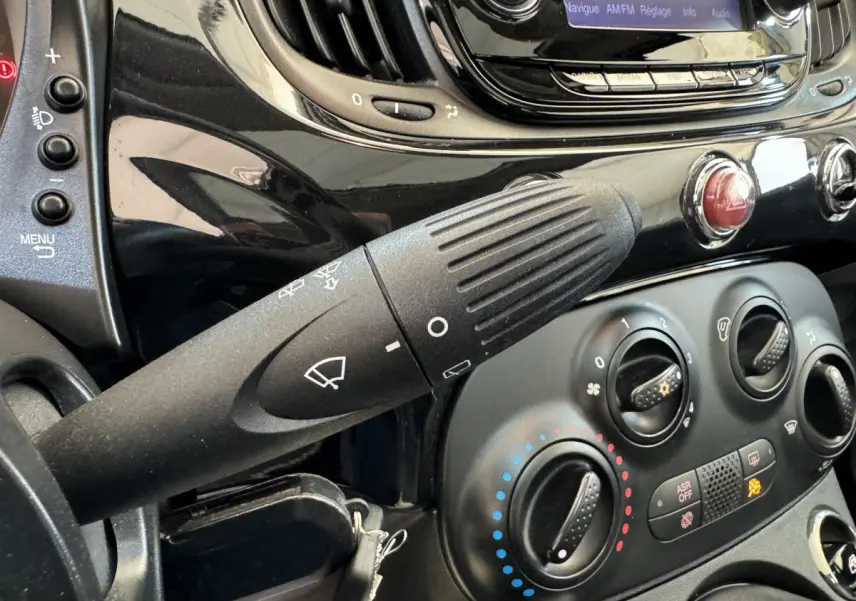 Gros plan sur la commande d'essuie-glace et la console centrale noire d'une Fiat 500 Lounge 2019.