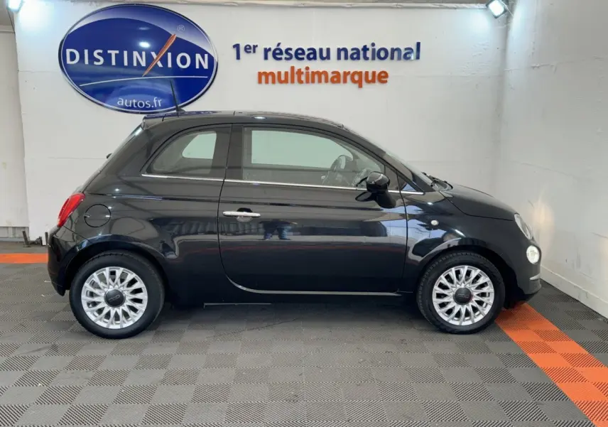 Profil droit d'une Fiat 500 noire 2019 avec jantes alliage et rétroviseurs noirs dans un showroom.