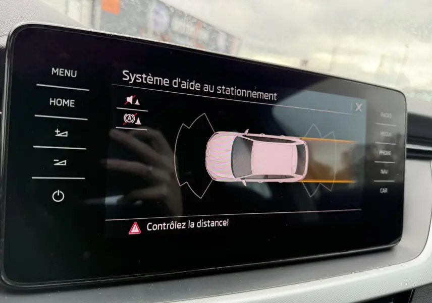 Écran tactile intérieur du système d'aide au stationnement de la Skoda Scala blanche, vue rapprochée du tableau de bord.