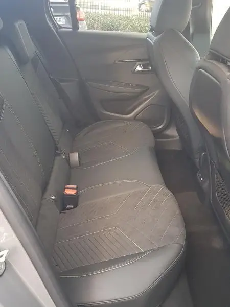 Vue latérale intérieure des sièges arrière gris de la Peugeot 208 Hybrid 110 e-DCS6 GT avec finitions en tissu et cuir.
