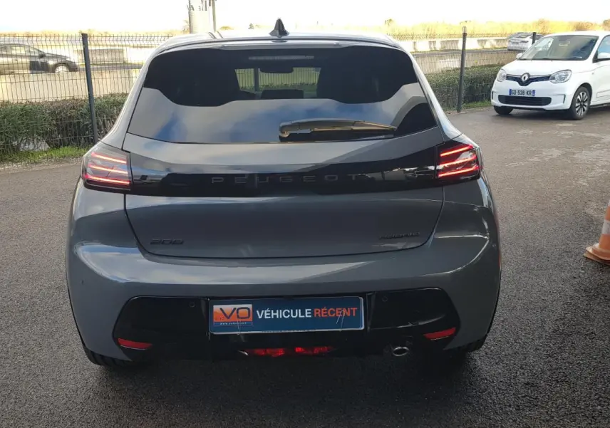 Vue arrière d’une Peugeot 208 Hybrid 110 gris métallisé avec feux LED allumés et jantes alliage 17 pouces.
