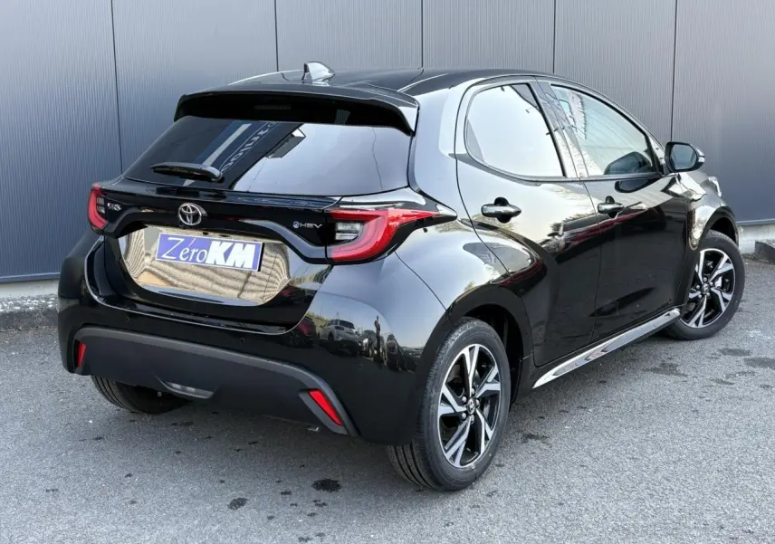 Toyota Yaris Hybride 2025 noir intense vue 3/4 arrière droit avec jantes alliage et vitres surteintées.