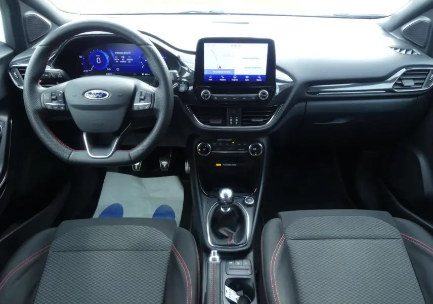 Intérieur noir du Ford Puma 2020 ST Line, vue frontale du tableau de bord avec volant sport et écran tactile central.