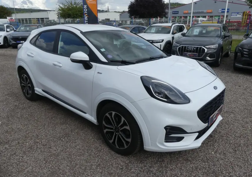 Ford Puma blanc en vue 3/4 avant droit avec jantes alliage et vitres arrière surteintées sur parking.