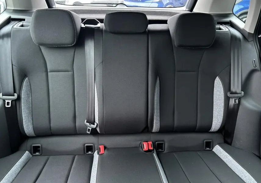 Vue arrière intérieure montrant la banquette arrière noire avec surpiqûres grises du Skoda Kamiq 2025.