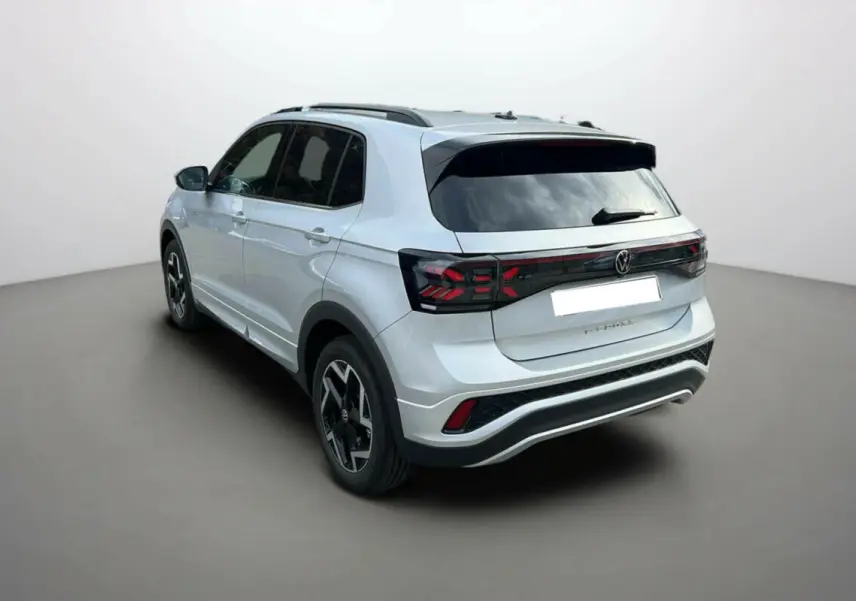 Volkswagen T-Cross gris argent en 3/4 arrière droit, avec jantes alu 18 pouces et vitres surteintées.