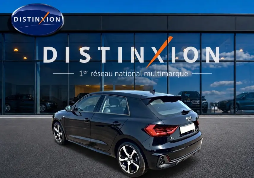 Audi A1 Sportback noir vue 3/4 arrière droit, avec jantes alu et becquet arrière distinctif.