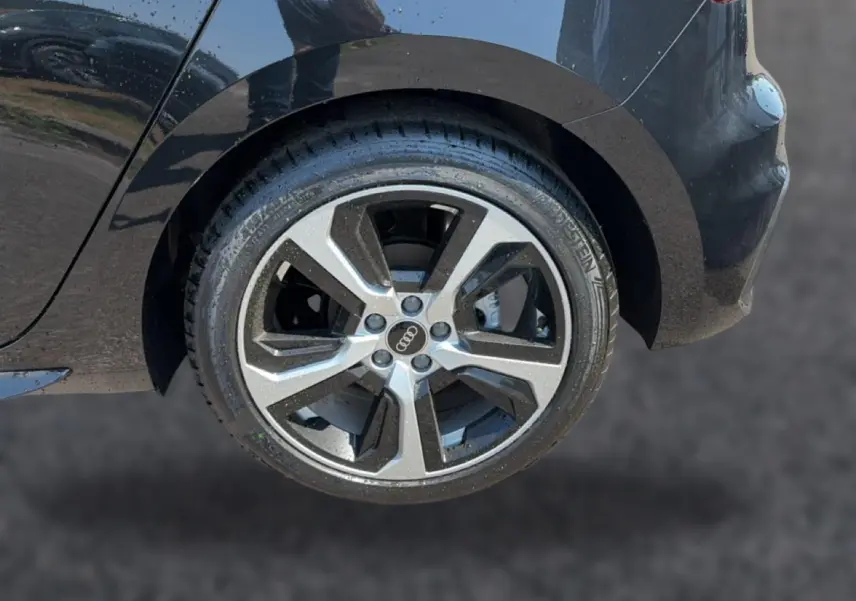 Gros plan sur la roue arrière droite noire d'une Audi A1 Sportback 30 TFSI S line avec jante alu distinctive.