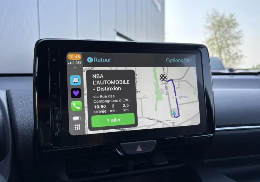 Écran tactile central de la Toyota Yaris hybride 2025 affichant un itinéraire GPS avec interface smartphone connectée.