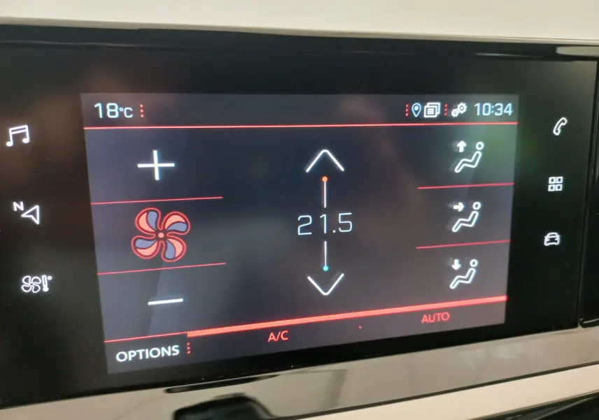 Écran tactile du système de climatisation affichant 21,5°C dans l'habitacle d'une Peugeot 208 blanche.