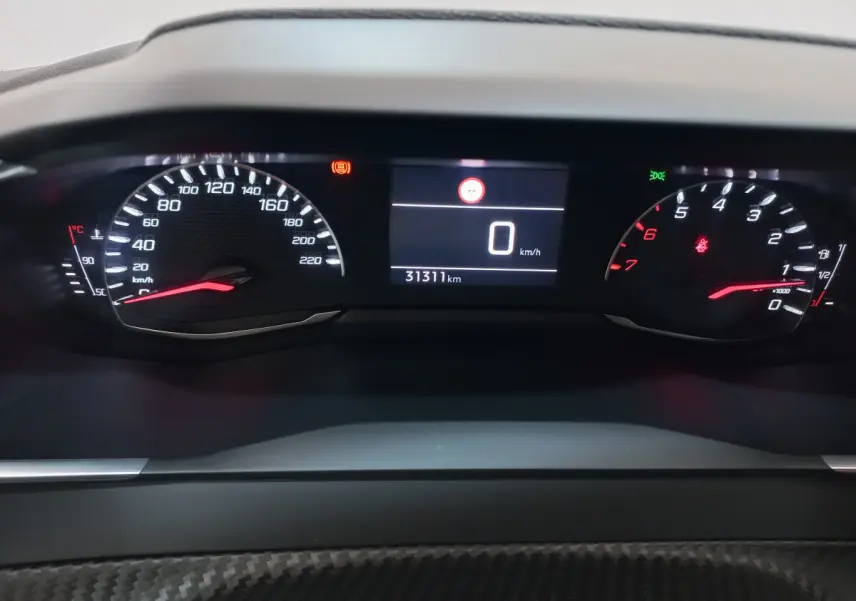 Tableau de bord numérique de Peugeot 208 blanc, affichage vitesse à 0 km/h et compteur kilométrique à 31311 km.