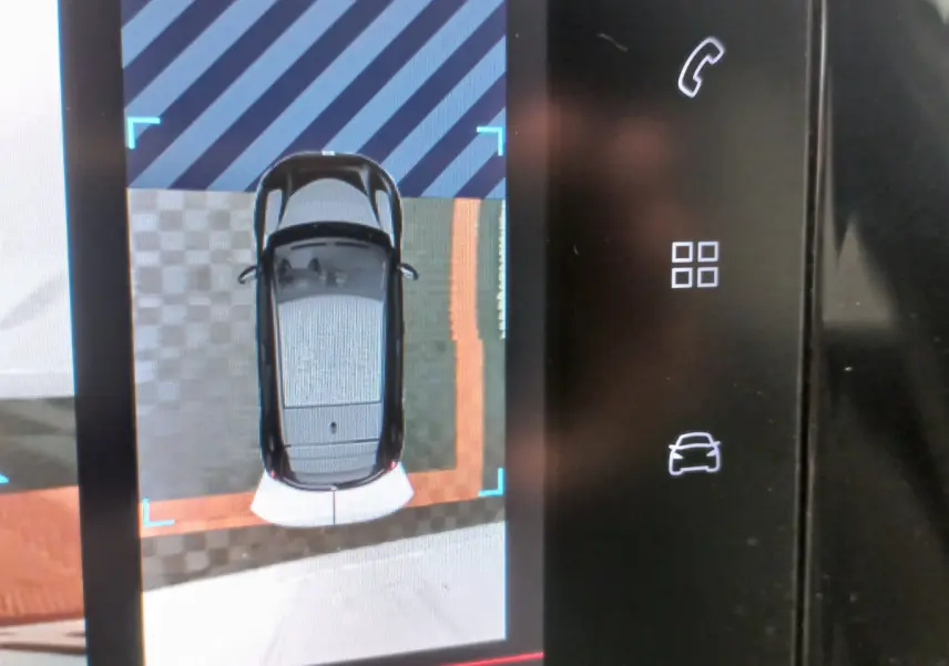 Affichage tactile montrant vue aérienne du véhicule blanc Peugeot 208 PureTech, avec icônes de contrôle sur la droite.