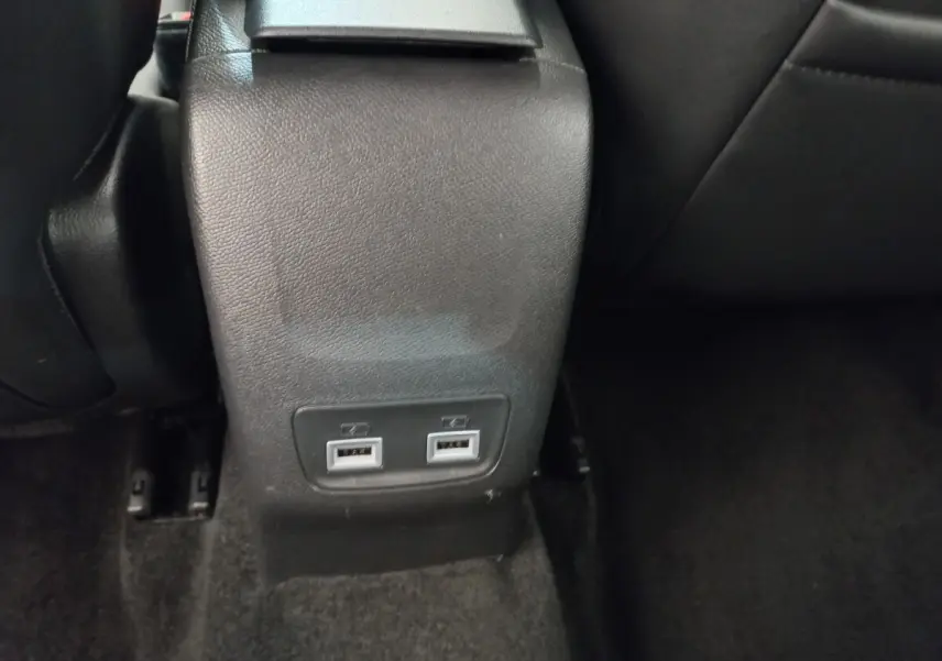 Prise double USB arrière sur console centrale noire dans l'habitacle d'une Peugeot 208 blanche PureTech 2021