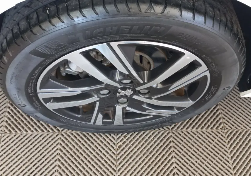 Gros plan sur la roue avant droite de la Peugeot 208 blanche avec jante alliage et pneu Michelin.
