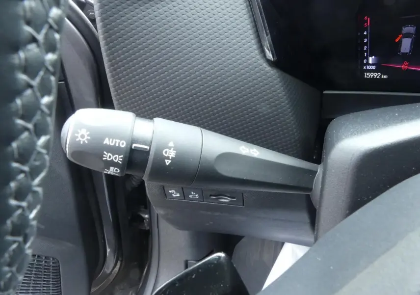 Gros plan sur la commande des feux et clignotants côté gauche du tableau de bord d'une DS4 gris métallisé 2024.