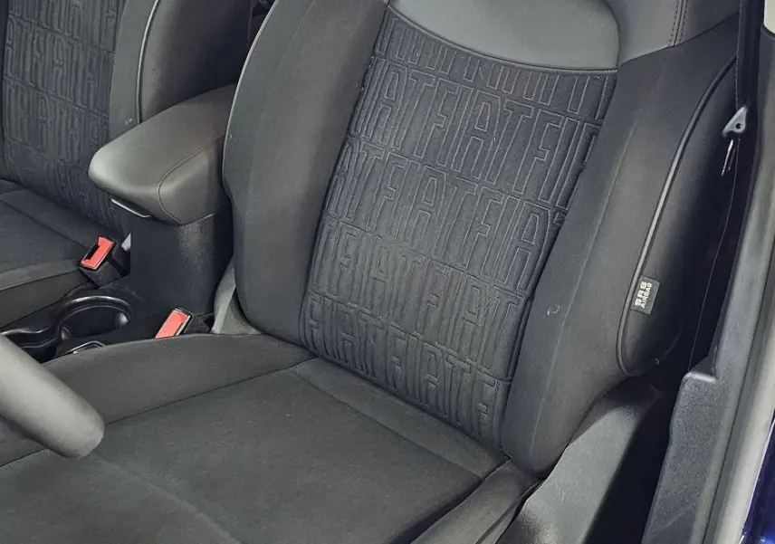 Vue intérieure côté conducteur du siège avant noir avec motifs FIAT, dans une FIAT 500X bleu 2024.