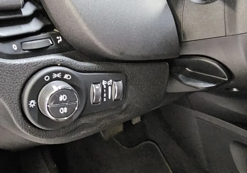 Détail du tableau de bord côté gauche du FIAT 500X 2024, montrant la commande des phares et réglages lumineux.