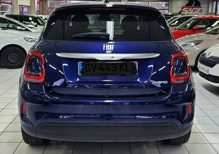 Vue arrière d'un FIAT 500X bleu hybride 2024, avec feux arrière distinctifs et logo FIAT centré sur le hayon.