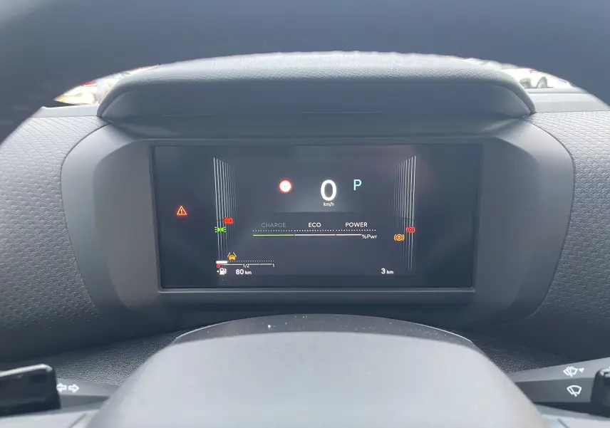 Vue rapprochée du tableau de bord numérique de la Citroën C4 hybride 2025, affichant la vitesse et indicateurs de conduite.