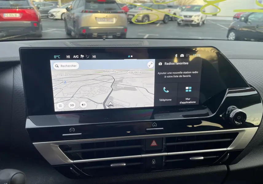 Vue intérieure du tableau de bord de la Citroën C4 2025 hybride, écran tactile affichant navigation et options radio.