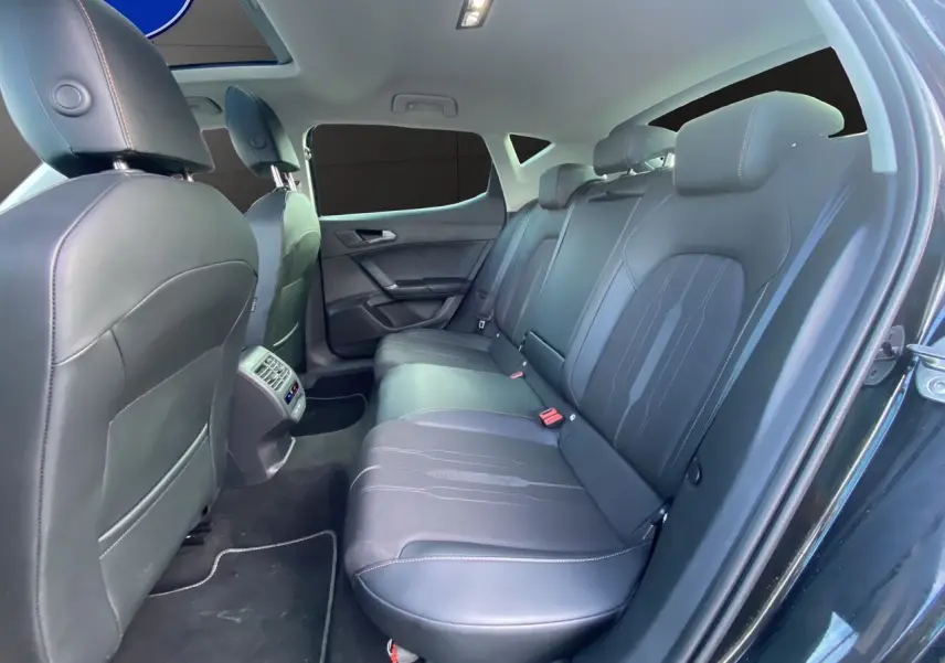 Vue intérieure côté droit des sièges arrière en cuir noir d'une CUPRA Leon 2023 avec toit ouvrant panoramique.