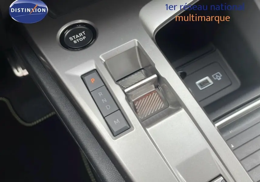Gros plan sur la console centrale grise du Peugeot 308 Hybrid 2026, avec bouton start/stop et sélecteur de boîte automatique.