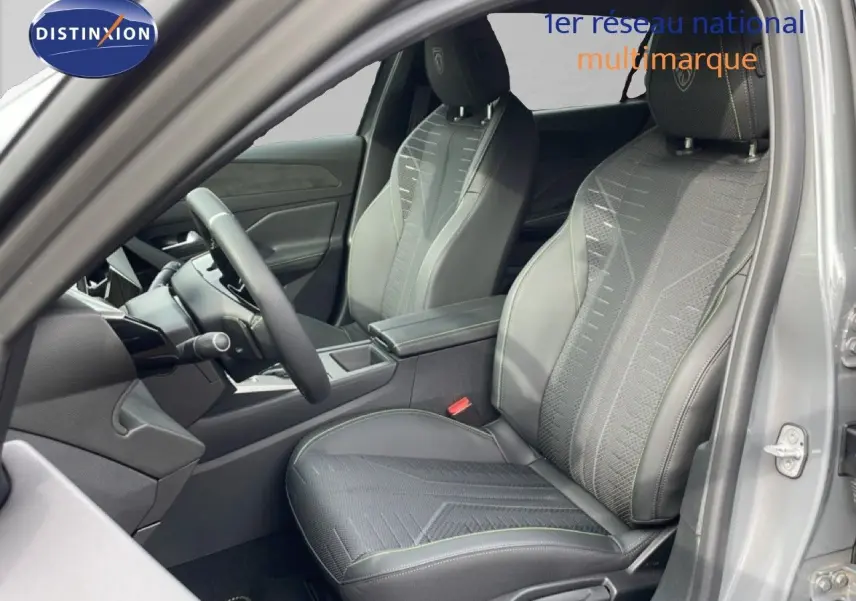 Vue intérieure côté conducteur de la Peugeot 308 gris selenium, sièges tissu et cuir avec surpiqûres vertes et volant multifonction.