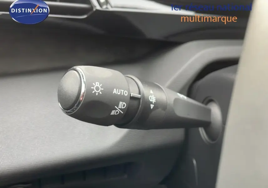 Gros plan sur la commande des phares à gauche du volant dans l’habitacle d’une Peugeot 308 gris selenium metal.