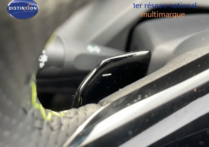 Gros plan sur la palette de changement de vitesse au volant d’une Peugeot 308 gris selenium 2026, intérieur noir.
