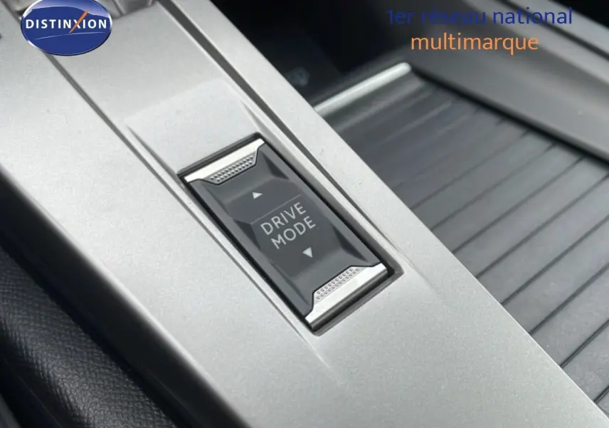 Gros plan sur le bouton Drive Mode intégré dans la console centrale grise du Peugeot 308 1.2 Hybrid 145ch GT.