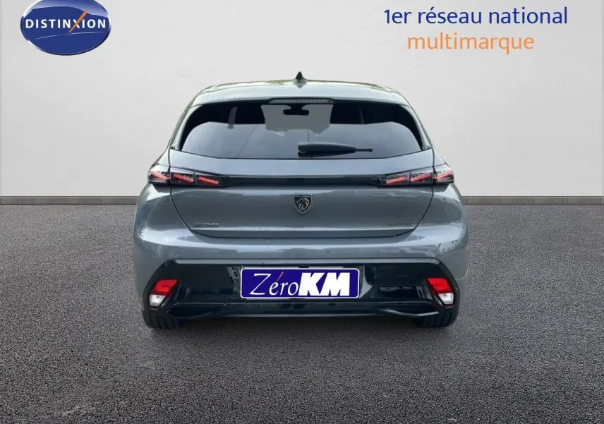 Vue arrière d'une Peugeot 308 gris selenium metal 2026 avec feux LED et logo central sur fond urbain neutre.