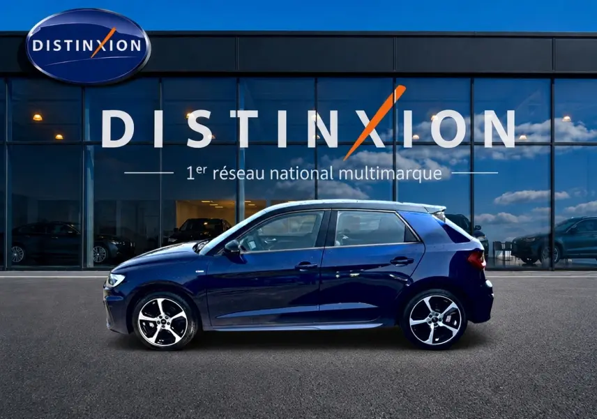 Audi A1 Sportback 30 TFSI S line bleu foncé vue de profil côté gauche devant une vitrine Distinxion.