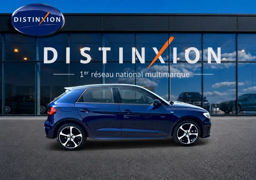 Audi A1 Sportback 30 TFSI S line bleu foncé vue de profil côté gauche devant une vitrine Distinxion.