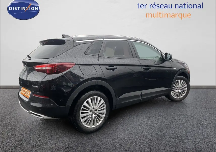 Opel Grandland X noir vue 3/4 arrière côté droit, avec jantes alliage et feux arrière allumés.