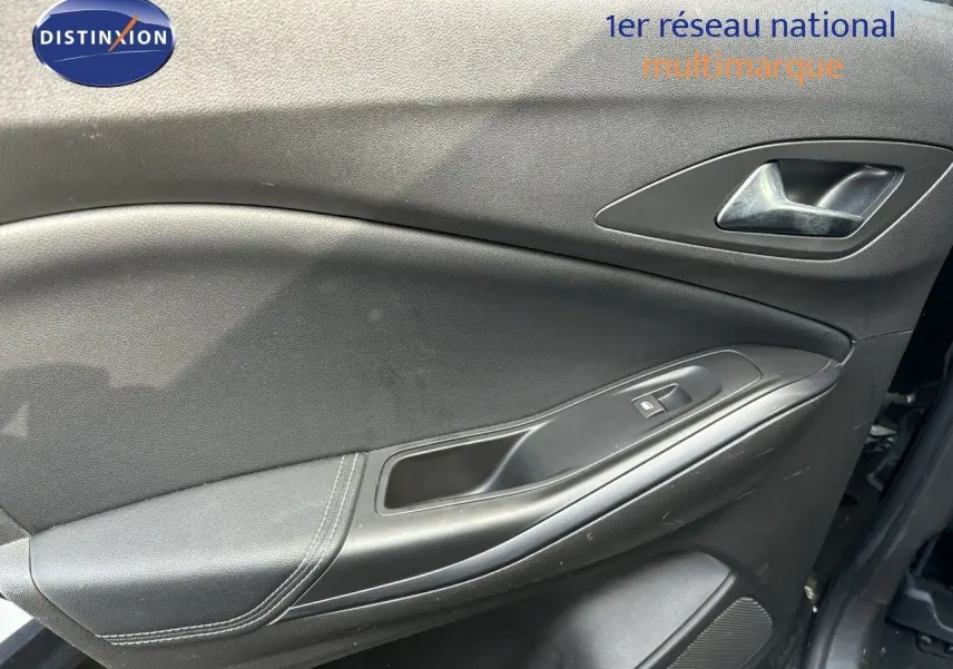 Gros plan sur la porte intérieure côté gauche de l'Opel Grandland X noir, avec poignée et commande de fenêtre visible.