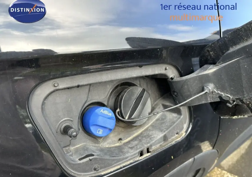 Gros plan sur la trappe à carburant noire d'un Opel Grandland X 2019 avec bouchon AdBlue bleu visible.