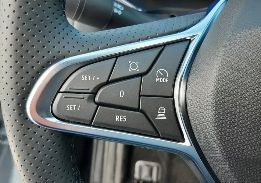 Gros plan sur les commandes de régulateur de vitesse au volant en cuir perforé de la Renault Symbioz gris rafale 2024.