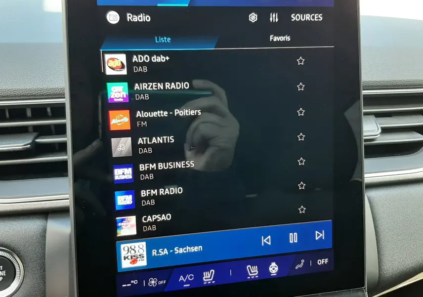 Écran tactile central de la Renault Symbioz 2024 affichant la liste des radios DAB avec commandes climatisation en bas.