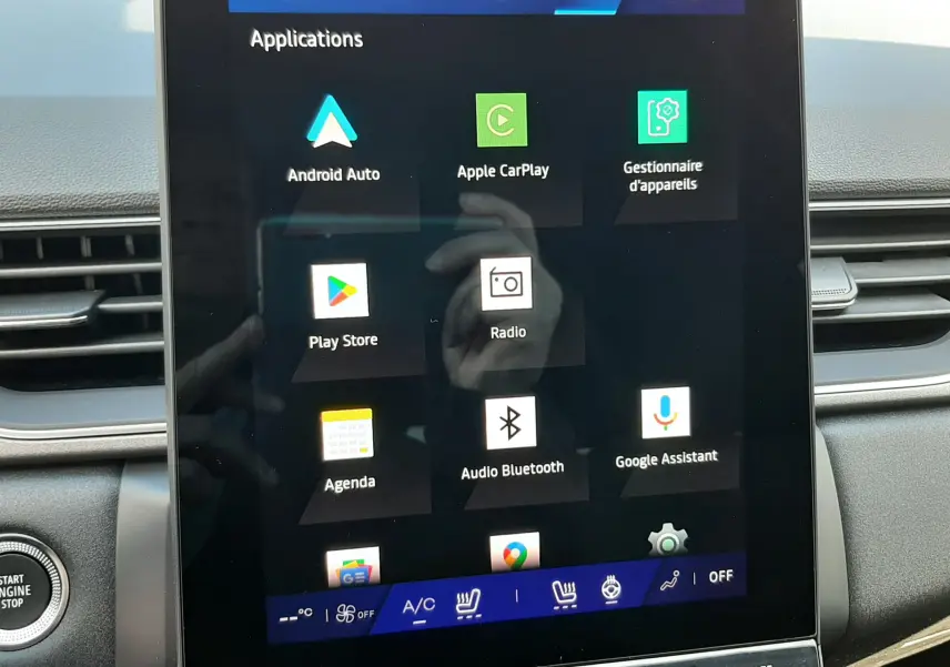 Écran tactile central affichant les applications multimédia dans l'habitacle gris du Renault Symbioz hybride 2024.