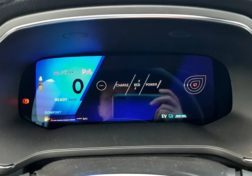 Affichage numérique du tableau de bord du Renault Symbioz gris Rafale, indiquant vitesse zéro et modes charge, éco et puissance.